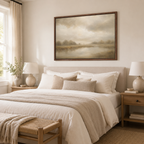 A framed landscape painting in soft beige and brown tones hangs above a neatly made bed in a bright, neutral-toned bedroom. Good Shepherd Christian wall art inspired by Psalm 23 showing a shepherd leading sheep beside still waters