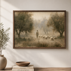 A framed landscape art print depicting Jesus walking with a flock of sheep through a misty, tree-lined field, styled on a wall above a wooden shelf with books and a vase.