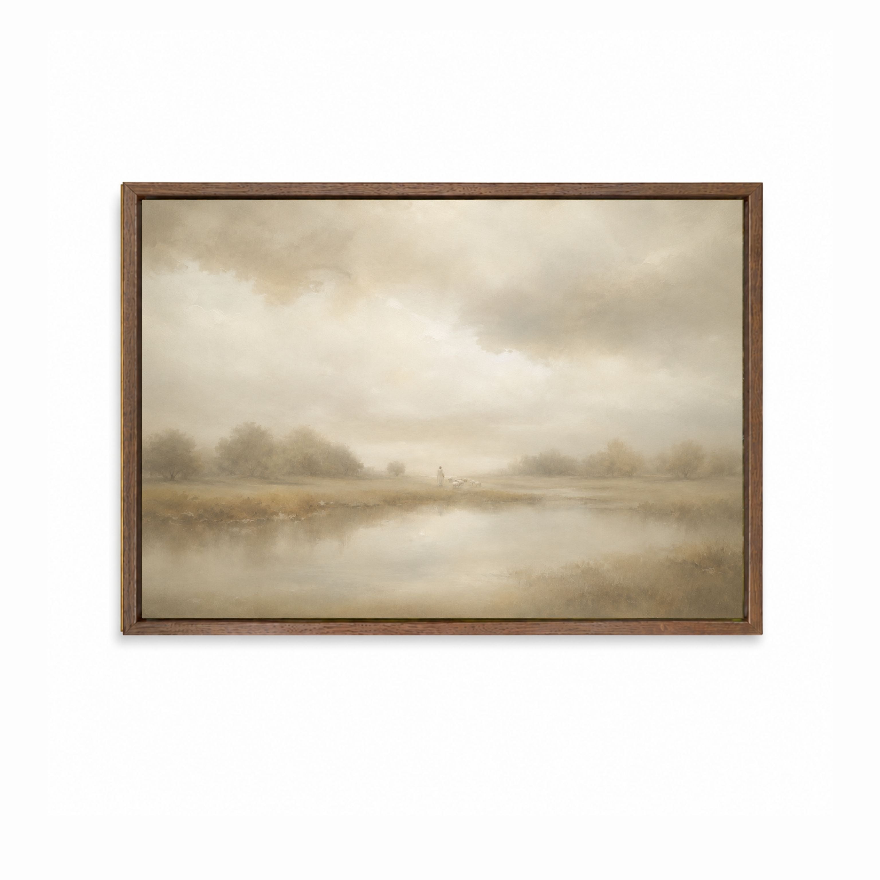 A framed landscape painting featuring Jesus with his lamb with soft beige and brown tones under a cloudy sky, set in a dark brown wooden frame. Good Shepherd Christian wall art inspired by Psalm 23 showing a shepherd leading sheep beside still waters