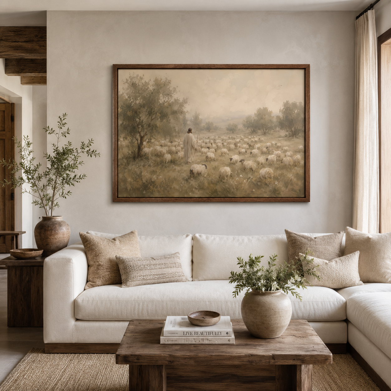 A large framed vintage-style painting depicting a shepherd tending a flock of sheep in a field, displayed on a beige wall above a white sectional sofa in a styled living room.